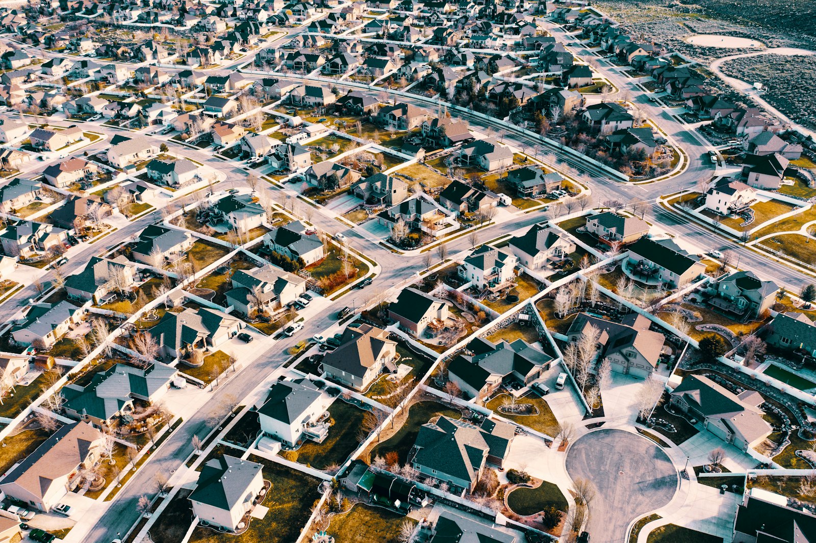 Aerial view of winding residential streets and rooftops in a suburban neighborhood