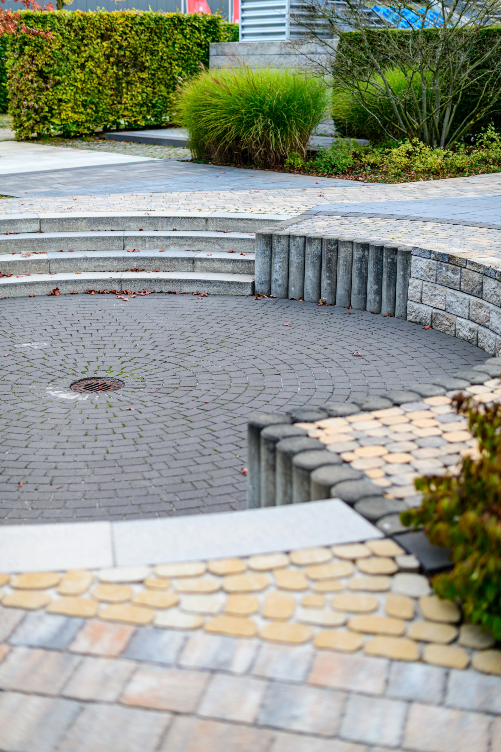 Circular paver courtyard with curved steps and fresh dark joint sand
